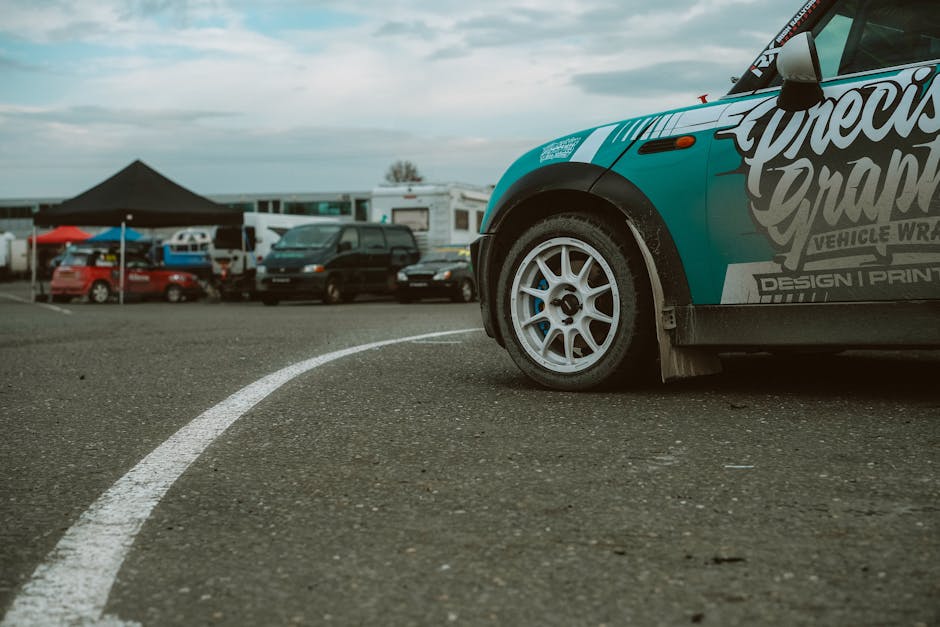 A teal modified Mini Cooper with white wheels at a track day event in Naas, Ireland.
