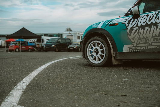 A teal modified Mini Cooper with white wheels at a track day event in Naas, Ireland.